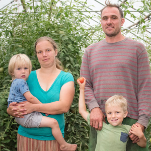 Farm family of four poses in greenhouse