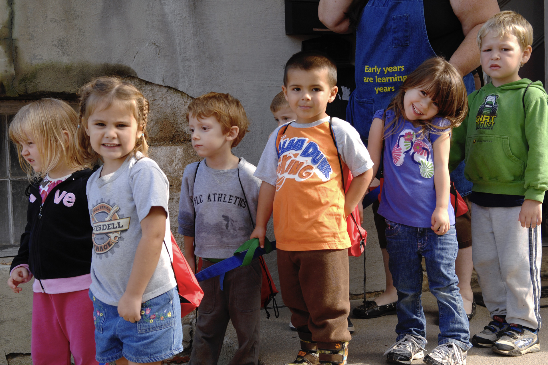 A group of toddlers waits in line