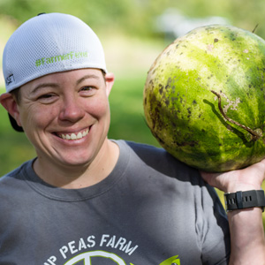 Worker with a Hip Peas Farm tee shirt carrying a watermelon