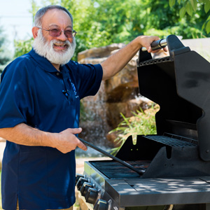 Man cooking on outdoor gas grille