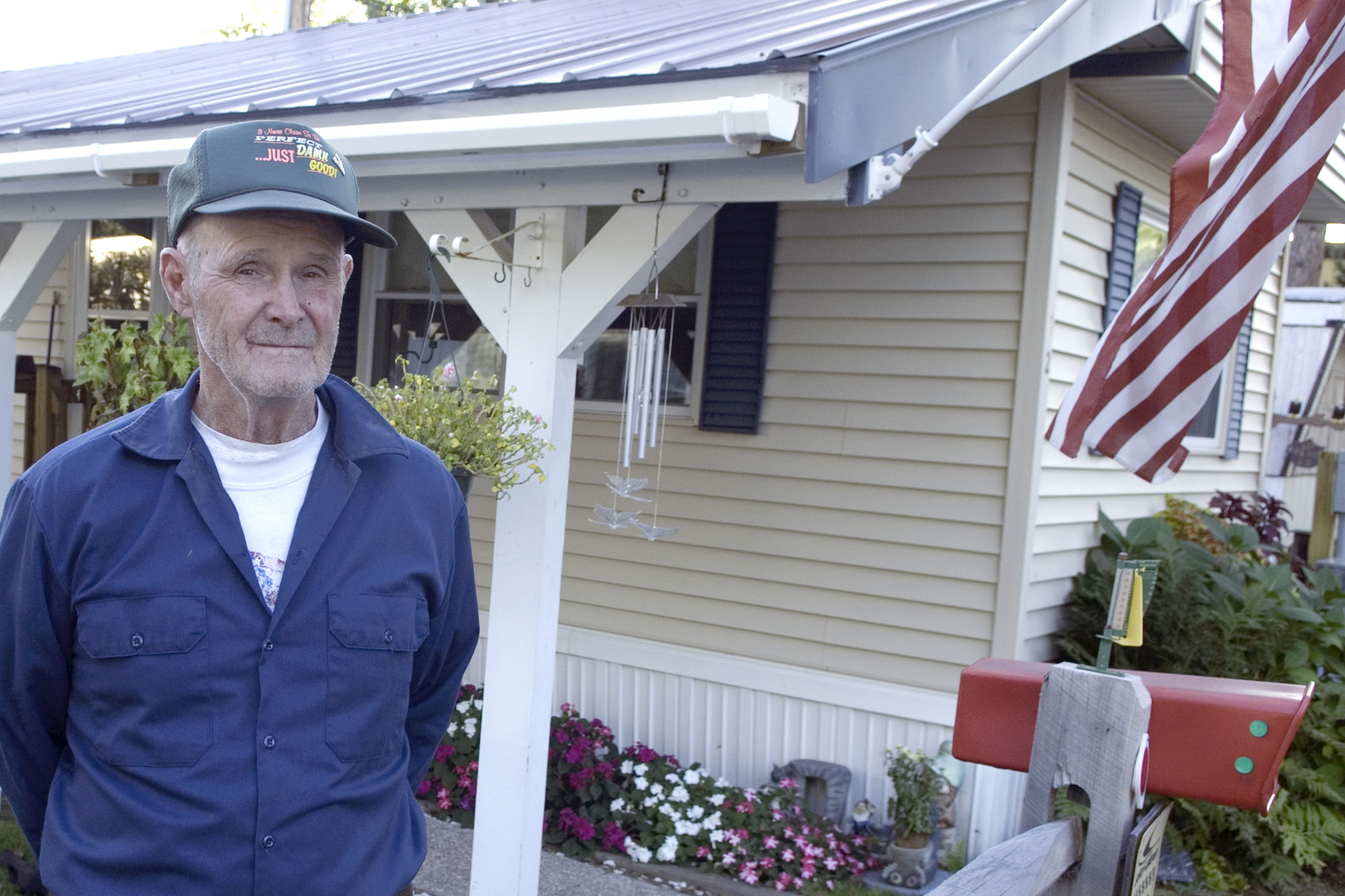 Man stands with manufactured home in background