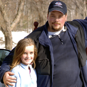 Man with hand on his daughter's shoulder