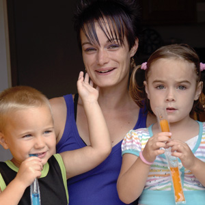 A young mom with her son and daughter, eating popsicles