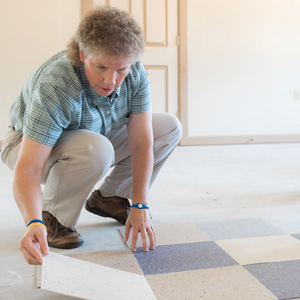 Woman setting down floor tile