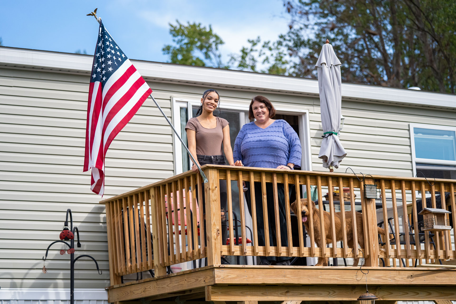 Jenn McLachlin and her daughter on the deck of their affordable manufactured home.