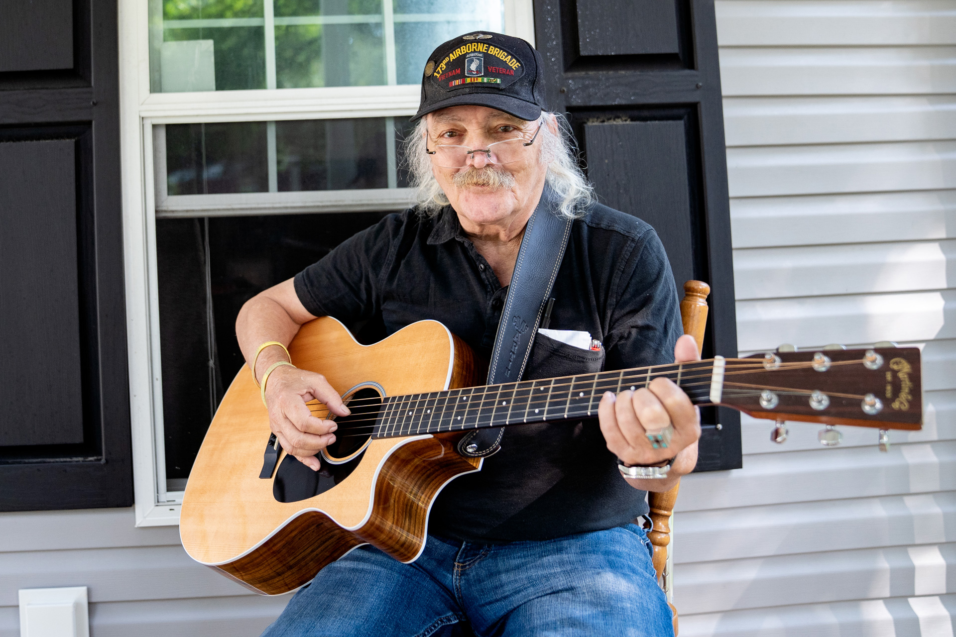 Grey-haired man playing guitar